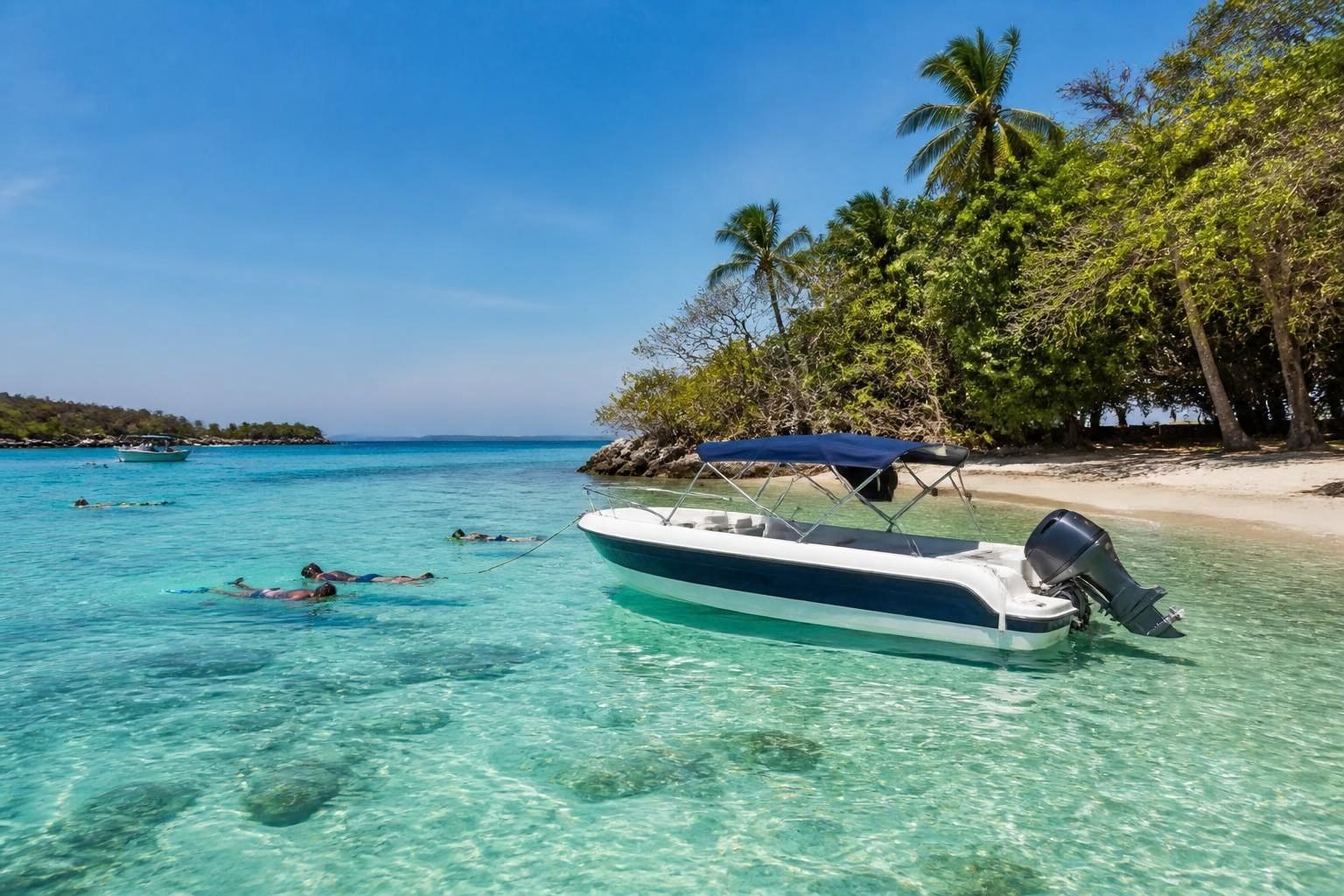 Boat anchored by a small island in turquoise water